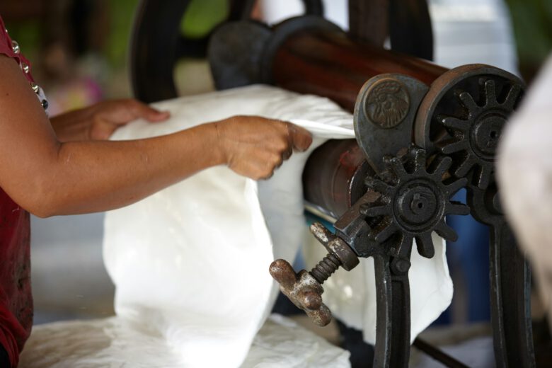 A woman manually ironing rubber resin sheets in Koh Yao Yai, Thailand