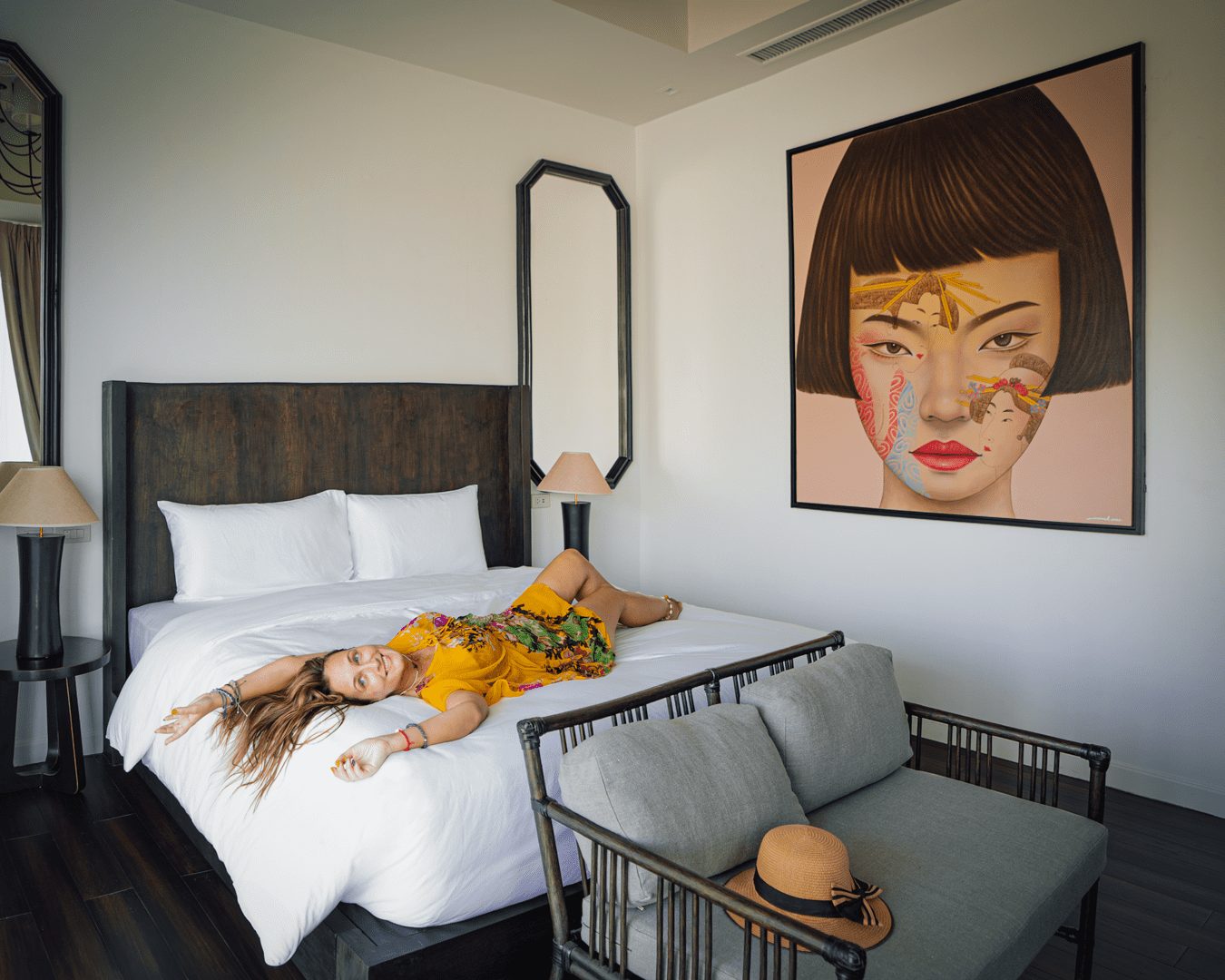 Guest relaxing in a Deluxe King Room with pool access and original artwork, Yao Bada Badoo, Koh Yao Yai